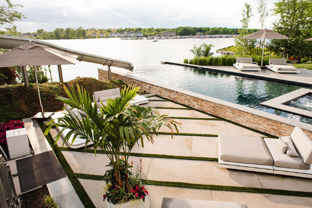 Infinity pool, stone wall and patio by OEG